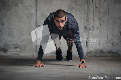 Image of Your mentality is your biggest strength. Portrait of a handsome young sportsman doing push ups while exercising inside a parking lot.