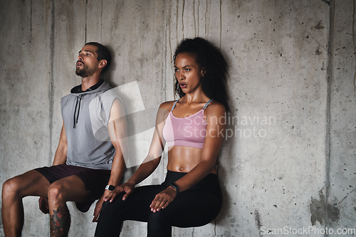 Image of Balance is the greatest form of strength. Shot of a sporty young couple exercising against a wall inside an underground parking lot.