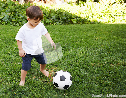 Image of Backyard soccer. A sweet little boy with a soccer ball in the backyard.