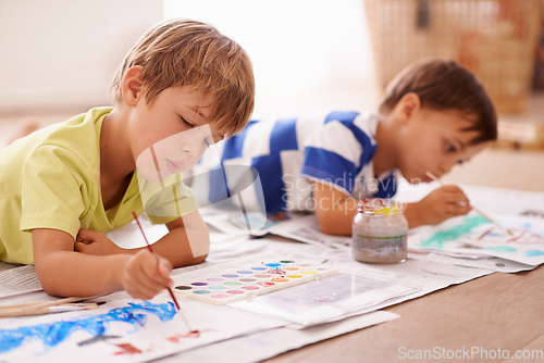 Image of Unleashing their inner artists. Shot of two young boys painting pictures at home.