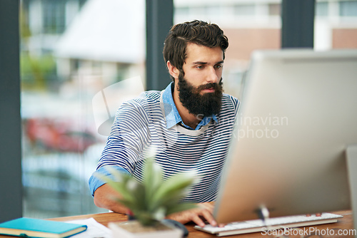 Image of This is what the new age of business looks like. Cropped shot of a creative businessman working on his computer in the office.