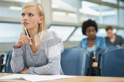 Image of Focused on her future. A beautiful young student listening intently in a lecture hall.