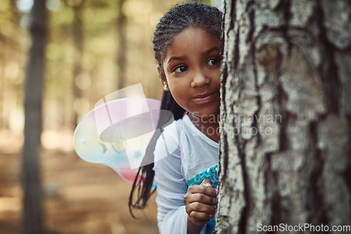 Image of Can you spot a cute fairy in the forest. Shot of a little girl dressed up as a fairy and playing in the woods.