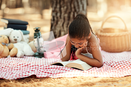 Image of Reading opens new worlds for kids. Shot of a little girl reading a book with her toys in the woods.