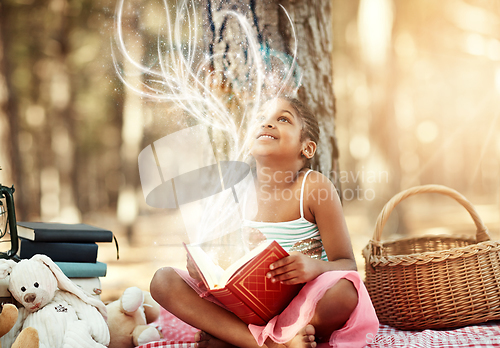 Image of Open a book and you open your mind. Shot of a little girl reading a book with her toys in the woods.