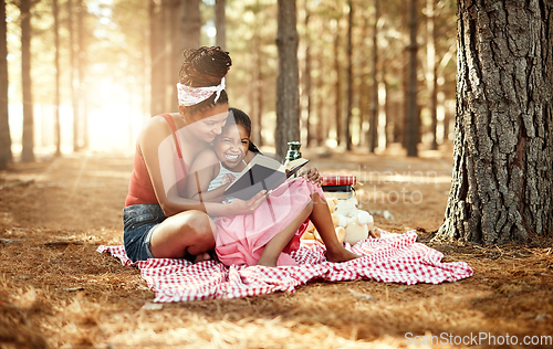 Image of Spark your childs imagination and stimulate curiosity through reading. Shot of a mother and her little daughter reading a book together in the woods.