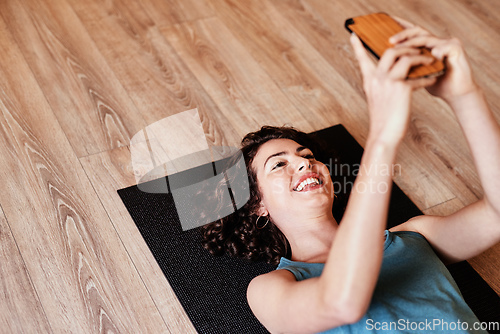 Image of When your pocket device becomes your personal trainer. Shot of a young woman using a smartphone during a yoga session.