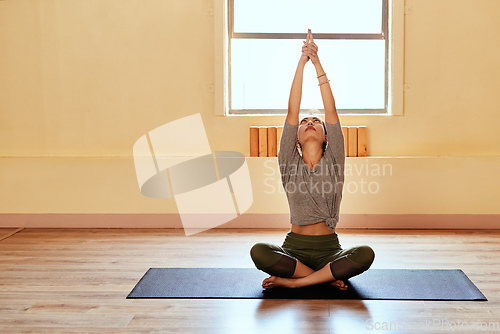 Image of Reach for your true potential. Shot of a young women meditating during a yoga session.