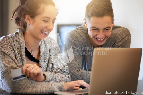 Image of Spending some money online. Shot of an affectionate young couple surfing the net while relaxing on the sofa at home.