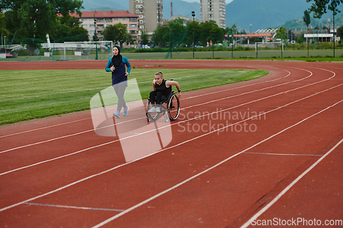 Image of A Muslim woman in a burqa running together with a woman in a wheelchair on the marathon course, preparing for future competitions.