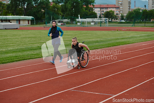 Image of A Muslim woman in a burqa running together with a woman in a wheelchair on the marathon course, preparing for future competitions.