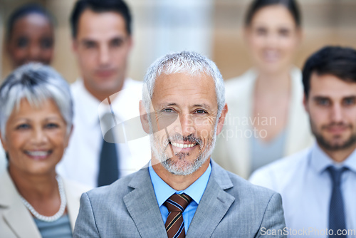 Image of We dont dream of success, we work for it. Portrait of a smiling businessman surrounded by a group of his colleagues.