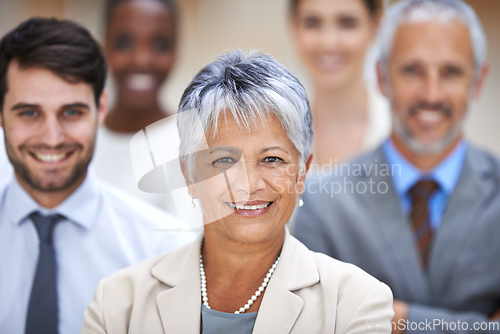 Image of Positive things happen to positive people. Portrait of a smiling businesswoman surrounded by a group of her colleagues.