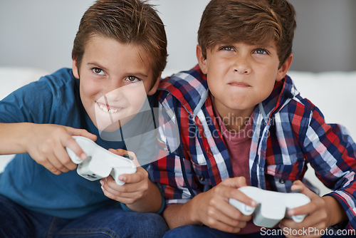 Image of Ive got you this time. Shot of two young boys playing video games at home.