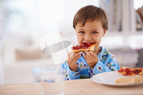 Image of Nothing beats a good breakfast. A cute little boy eating toast with jam.