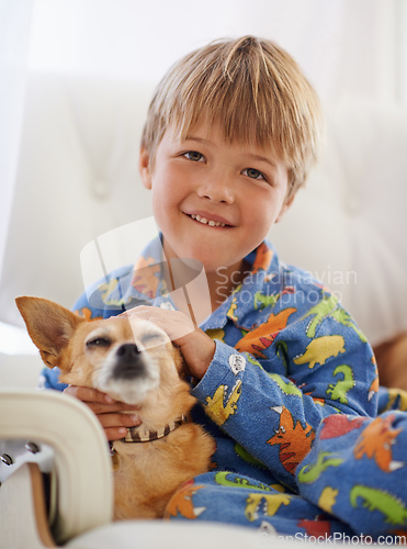 Image of Snuggling his old friend. A cute little boy cuddling his dog on the couch.