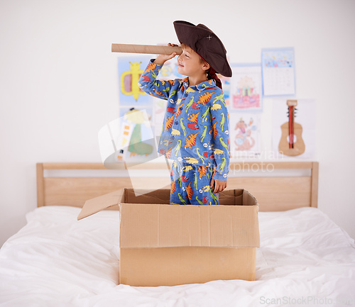 Image of Is that a whale. A little boy playing pirate in a cardboard box.