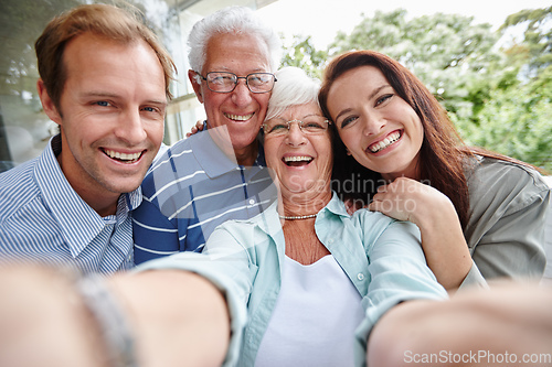 Image of The generation of selfies. Cropped shot of four adults taking a family selfie.