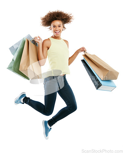Image of Payday delight. Studio portrait of an excited young woman carrying shopping bags and jumping for joy against a white background.