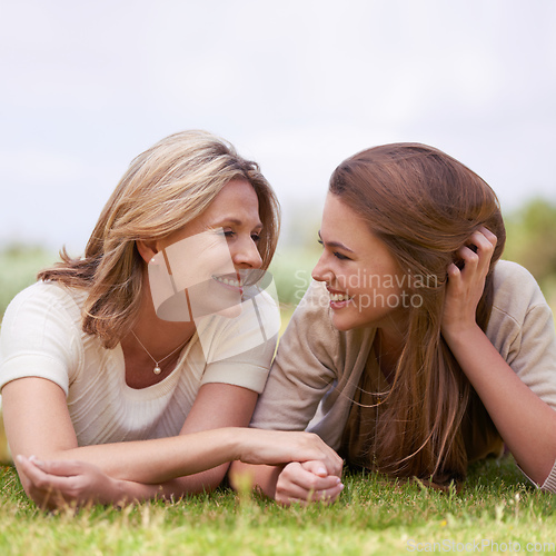 Image of Special time with her daughter. A loving mother and daughter lying side by side on the grass.