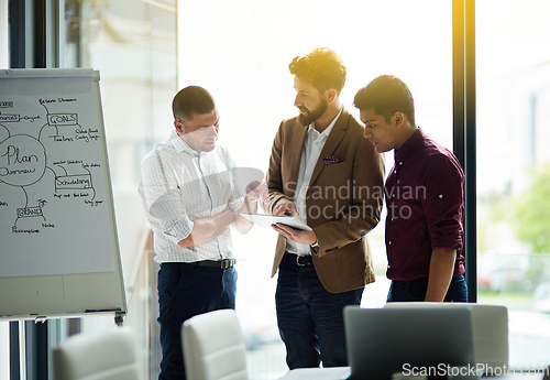 Image of Sharing the latest updates together. Cropped shot of a group of colleagues having a discussion in an office.