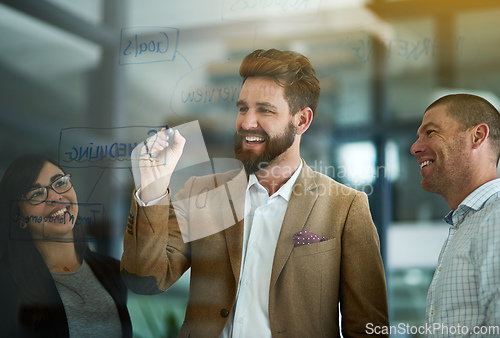 Image of Success forms when brilliant minds come together. Cropped shot of a group of colleagues brainstorming on a glass wall in an office.