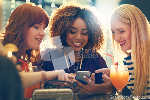 Image of Deciding which selfie to share. Shot of a group of happy friends enjoying cocktails in a nightclub.