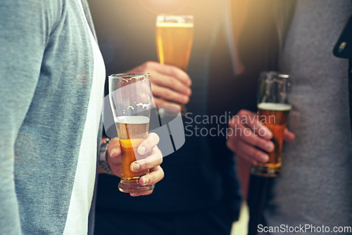 Image of Good friends, good beer. Cropped shot of a group of unidentifiable friends enjoying a beer together.