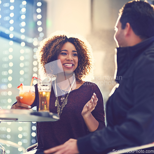 Image of Drinks are on you, right. Shot of two friends relaxing with cocktails in a nightclub.