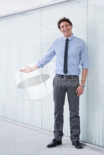 Image of Welcome to our office. Full length shot of a young businessman gesturing with his arm.