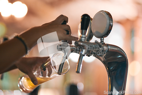 Image of Pouring the first one of the day. Shot of an unrecognizable person pouring a beer from a tap inside of a beer brewery during the day.