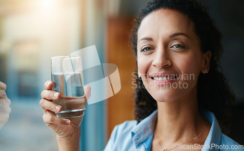 Image of Working on my daily water goal. Portrait of a woman drinking a glass of water at home.