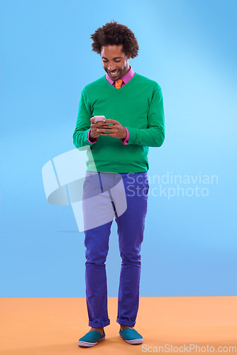 Image of Status update Looking sweet. Studio shot of stylish young man talking on the phone against a colorful background.