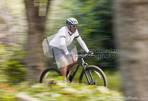 Image of Freedom, fitness and man cycling in forest with energy, training or nature, workout and off road race. Speed, workout and cyclist on mountain bike for extreme sports, adrenaline or power performance