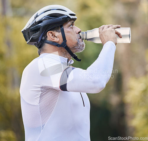 Image of Cycling, fitness and senior man drinking water in park for hydration during training exercise in nature. Bottle, thirsty and elderly athlete with electrolytes break or sports liquid in forest workout
