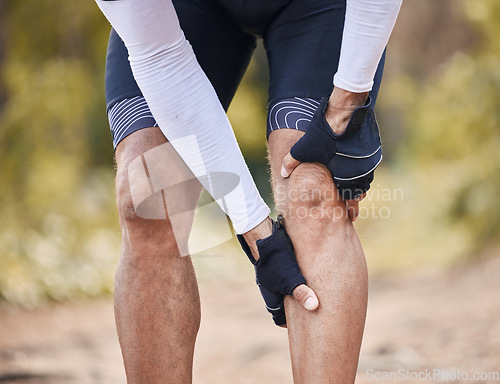 Image of Fitness, knee pain and man hands in forest with cycling, sports or injury, muscle or joint accident outdoor. Leg, arthritis or athlete with fibromyalgia, emergency or cramps massage for osteoporosis