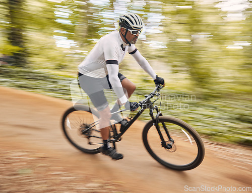 Image of Blurred speed, cycling and man in nature training for a race, marathon or competition in a forest. Fast, fitness and male cyclist athlete riding bicycle for cardio exercise or workout on a mountain.