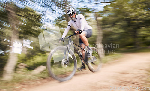 Image of Nature blur, mountain bike and sports man cycling, action and ride bicycle for cardio, fitness or outdoor exercise. Low angle, fast motion and extreme cyclist training, speed and danger risk in woods