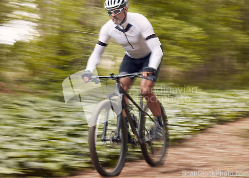 Image of Fast, fitness and man on a bike in nature for a race, sports or fitness. Energy, mountains and a male cyclist on a bicycle in the woods with speed for exercise, cardio or training in a forest