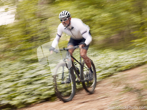 Image of Fast, cycling and man on a bike in nature for fitness, sports or a competition. Energy, mountains and a male cyclist on a bicycle in the woods with speed for exercise, cardio or training in a forest