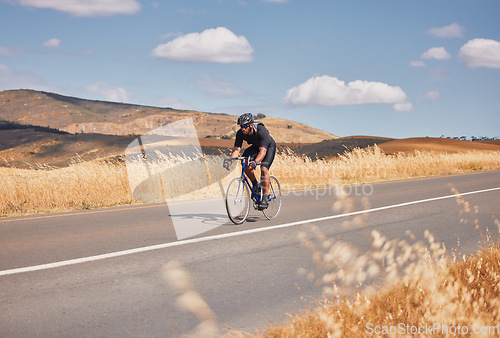 Image of Fitness, nature and man cycling on road for workout, exercise and scenic mountain path. Health, wellness and cyclist on bike on summer morning for training, practice and bicycle race with blue sky.