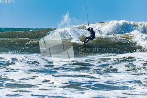 Image of Kitesurfer riding ocean waves