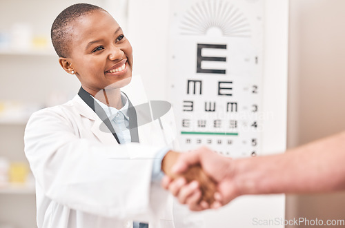 Image of Optometrist woman, handshake and smile with patient, customer and happy for agreement, deal or sale. African ophthalmology doctor, shaking hands and kindness for healthy eyes, wellness or healthcare