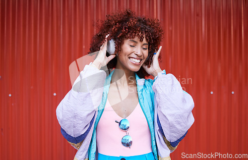 Image of Music, dance and headphones with a retro woman on a red background in the city for energy or freedom. Radio, smile and streaming audio with a happy young afro person listening to sound for wellness
