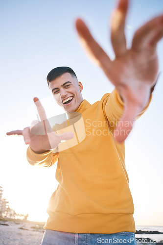 Image of Frame, summer and a man with hands at the beach with happiness, freedom and creativity. Smile, portrait and a young person at the sea with a gesture for perspective on a vacation at the ocean