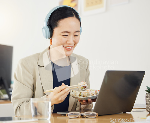 Image of Japanese business woman, laptop and sushi on lunch, video or movie in office for thinking, headphones and happy. Asian entrepreneur, eating seafood and comedy with computer, chopsticks and streaming