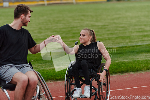 Image of A woman with disability in a wheelchair talking with friend after training on the marathon course