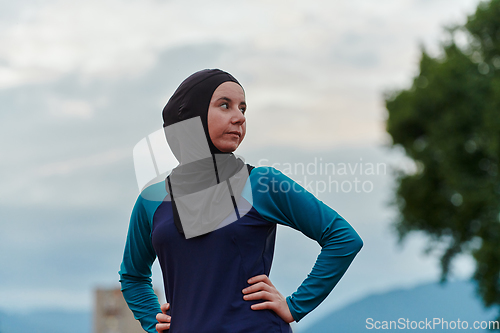 Image of A Muslim woman with a burqa, an Islamic sportswoman resting after a vigorous training session on the marathon course. A hijab woman is preparing for a marathon competition