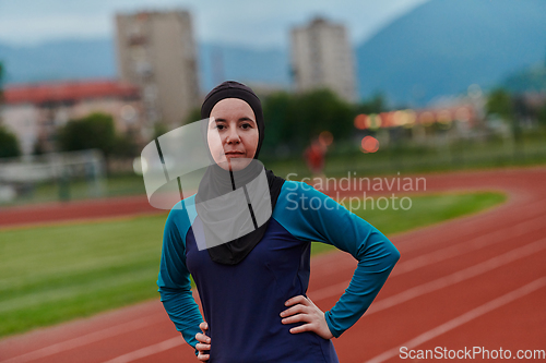 Image of A Muslim woman with a burqa, an Islamic sportswoman resting after a vigorous training session on the marathon course. A hijab woman is preparing for a marathon competition