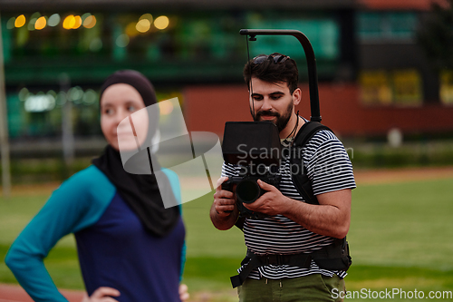 Image of A cameraman filming the participants of the Paralympic race on the marathon course